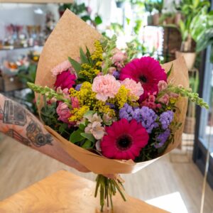 Ramo Encanto de flores frescas variadas con verdes naturales.