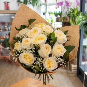 Ramo de rosas blancas frescas con paniculata y verdes naturales.