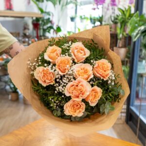 Ramo de rosas color melocotón frescas con paniculata y verdes naturales